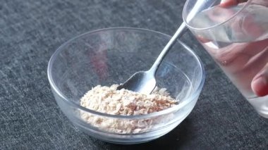 Yulaf ezmesine su dökerek. ,