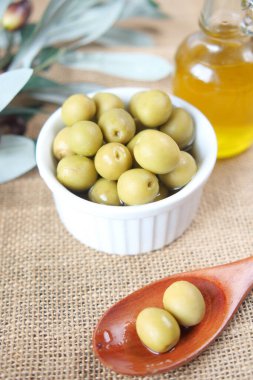 Bir şişe zeytinyağı ve taze zeytin.