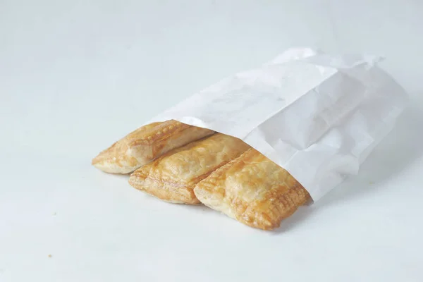 slice of apple pie cake in a take away packet on white ,