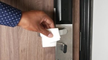 Kapı topuzunu peçeteyle temizleyin. .