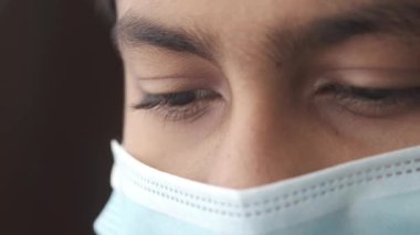 Yüzünde maske olan genç erkeklerin gözlerini kapat. .