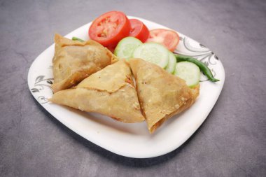 Tabakta Hint samosası ve domates manzarası. .