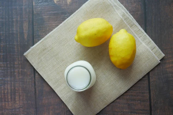 Yellow Lemon and glass of milk on table ,