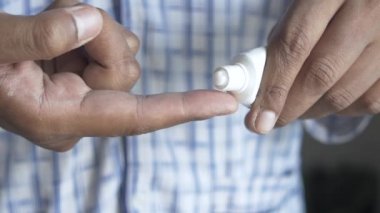 Antibiyotik kremi süren bir adam.