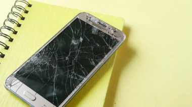 Renk arkaplanındaki bozuk akıllı telefonun üst görünümü.