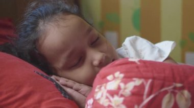 Öksüren çocuk. Yatağın üstünde uzanmış yatıyor. .