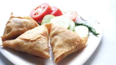 Tabakta Hint samosası ve domates manzarası. .