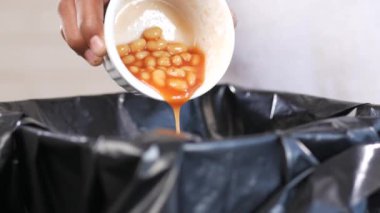 Teneke kutuyu çöp kutusuna atmak. .