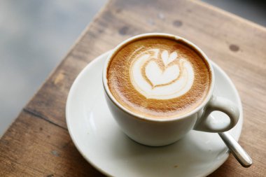 Kafenin tepesinde çiçek desenli geç kalmış bir fincan kahve. .