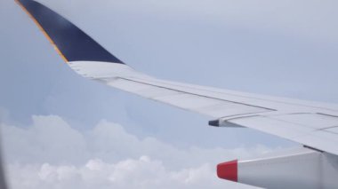 Bulutların üzerinde uçan uçağın kanat.