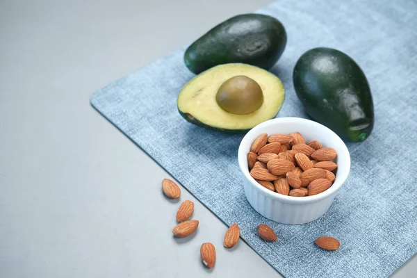 f slice of avocado and almond nut on table with copy space .