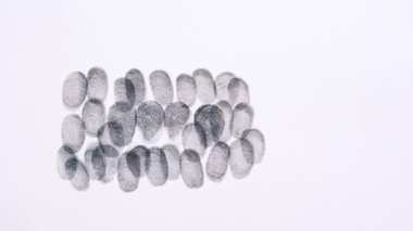 Kapalı bir kağıtta farklı siyah parmak izleri.