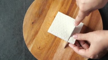  Soya peynirini bıçakla kesen ellerin üst görüntüsü ,
