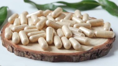 Bitkisel ilaç kapsülünün beyaza düşüşünün üst görüntüsü ,