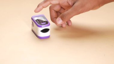  Nabız oksimetresi kullanan genç bir adam..