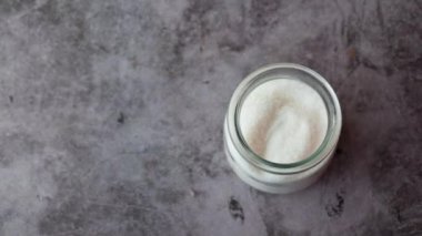 Siyah arkaplanda beyaz şeker ve kaşık