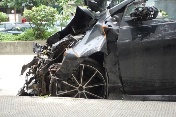 black car damaged by a road accident .