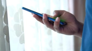 Akıllı telefon kullanarak genç adamın elini kapat.