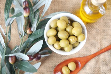 Bir şişe zeytinyağı ve taze zeytin.