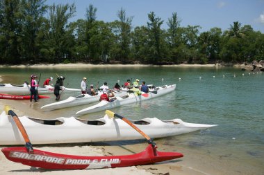 Gün batımında sörf yapan bir grup insan 