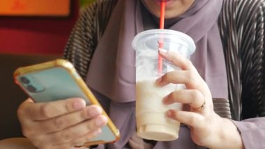 young women drinking banana milk shake at cafe .