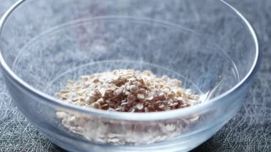 Yavaş hareket eden yulaf gevrekleri bir kasenin üzerine düşüyor. ,