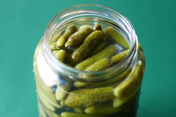 bottle of pickled cucumbers, pickles on table .