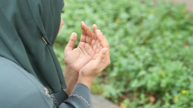  rear view muslim women hand praying outdoor ,