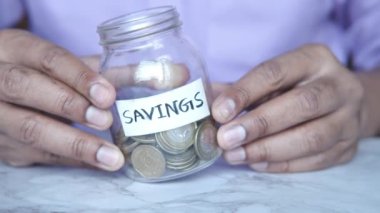 Genç adam kavanozda para biriktiriyordu. .