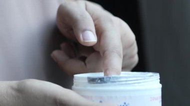 Kadın ev manzarasında cildine güzellik kremi sürüyor..