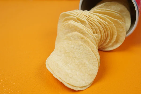 potato chips spilling form a packet on table ,