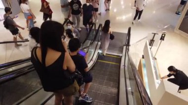 Singapur 12 Haziran 2022, Plaza Singapur 'da yürüyen merdivende alışveriş yapanlar.