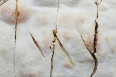 Masadaki pizzanın detaylı görüntüsü.,