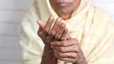 Elderly woman suffering in hand ,