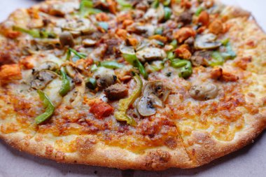 Tahta masadaki bir tabakta peynirli pizza.