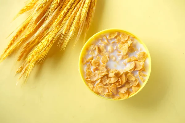 corn flakes and milk in a yellow color bowl ,