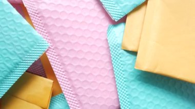 yeşil ve pembe renkli kağıt baloncuk zarfı masanın üstünde .