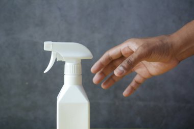  men reaching for a spray bottle on black ,