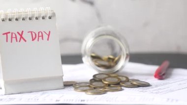 tax day concept with calendar, pen and coins on table ,