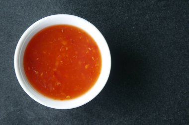 chili tomato sauce in a small jar on table ,