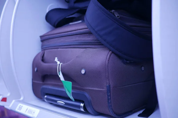suitcase in a overhead baggage area in a Airplane cabin ,