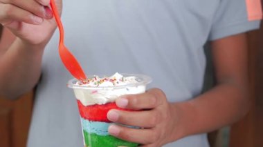 Masadaki plastik kutuda gökkuşağı renkli pasta ,