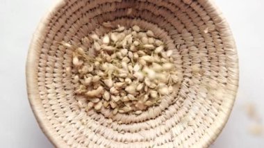  slow motion of dropping jasmine dry flower in a container on table .