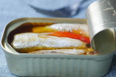 Beyaz karolar üzerinde sardalya konservesini aç