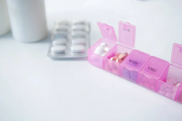 close up of medical pills in a pill box on table .