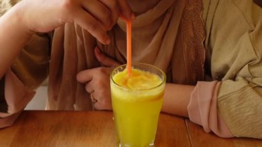  young women drinking orange juice.
