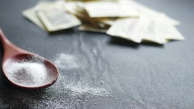 Sugar Substitute sweetener on a wooden spoon on black ,