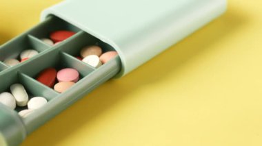 Tıbbi hapları masanın üzerindeki ilaç kutusuna koy. .