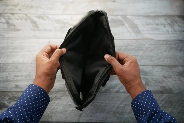 young man searching something in a shoulder bag .