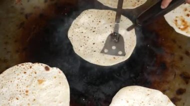  cooking roti chapati on a big cooking pan ,
